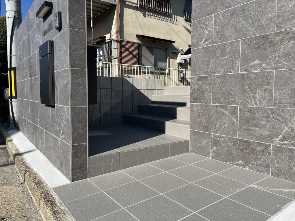 建物の落ち着いた外観に合わせて仕上げたアプローチと階段